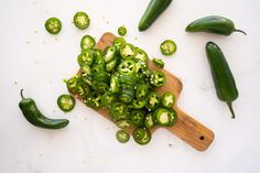 green peppers are on a cutting board with some cut up ones