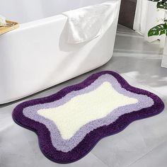 a bath mat that is on the floor in front of a white tub and toilet