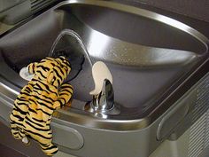 a yellow and black towel sitting on top of a metal sink