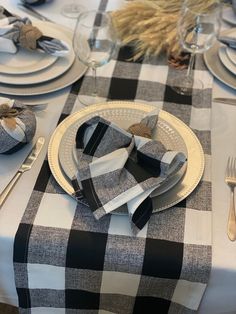 the table is set with black and white checkered linens, silverware, and napkins