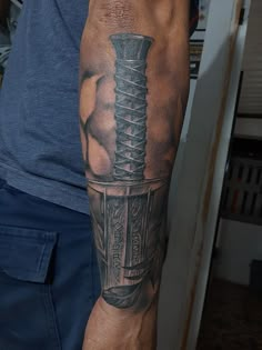 a man with a tattoo on his arm holding a knife