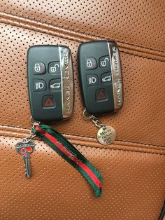 two car keys are attached to the handle of a brown leather suitcase with a red and green ribbon around it