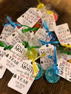 small tags with words and ribbons tied around them on a wooden table in front of other tags that say it's the most wonderful year