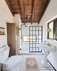 an instagramted photo of a white bathroom with black and white tile flooring