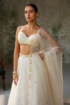 Ivory skirt with aari, sequin, thread embroidery in floral pattern. Paired with sleeveless embroidered padded blouse and dupatta. - Aza Fashions Festive Dresses With Sweetheart Neckline, White Bollywood Sleeveless Lehenga, White Sleeveless Bollywood Lehenga, White Bollywood Lehenga, Festive Sleeveless White Lehenga, Festive White Sleeveless Lehenga, White Embellished Sleeveless Set, Elegant Off White Embroidered Choli, Elegant Embroidered Off-white Choli