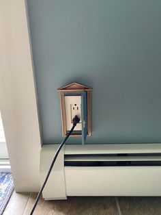 an electrical outlet is plugged into the wall with a black wire attached to it