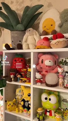 a shelf filled with lots of different types of stuffed animals and plants on top of it