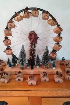 a wooden table topped with lots of christmas decorations and a ferris wheel in the background