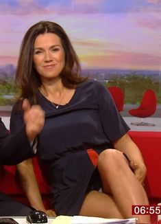 a man and woman sitting on a red couch in front of a tv screen, giving the thumbs up sign