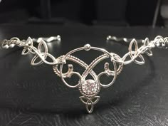 I will fabricate this stunning sterling silver, Celtic Elvish inspired tiara designed with a total of 6 Celtic Trinity Knots balanced between woven wire work and delicate scroll designs. I'll set an 8mm gemstone, of your choosing, in the drop down menu! This piece is a joy for me to fabricate. I love all things Celtic and magical and I feel this represents both nicely. This piece will fit any hair style and any head shape. I make them to fit approximately behind the ears and then use a jeweler's Wedding Circlet, Bohemian Headpiece, Stevie Nicks Style, Wire Wrap Jewelry Designs, Bridal Diamond Jewellery, Celtic Wedding, Irish Wedding, Magical Jewelry, Bridal Tiara