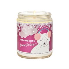 a candle in a glass jar with a pink background and white snowflakes on it