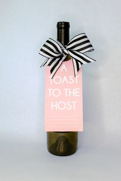 a wine bottle with a bow on it and a sign that says toast to the host