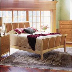 a bed sitting on top of a wooden floor next to a window