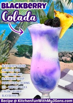 a purple drink with blackberries in it and a yellow star on the top is next to a beach