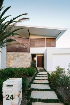 a modern house with stone steps leading to the front door