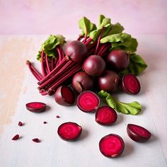 beets and greens on a cutting board next to each other