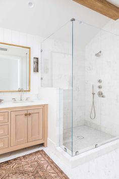 a bathroom with a walk in shower next to a sink and a mirror on the wall