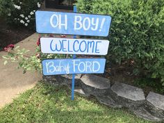 a blue and white welcome sign in front of some bushes