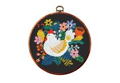 a cross stitched picture of a chicken with flowers on it's back side