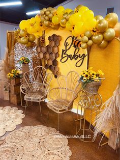 yellow balloons and chairs are on display at the baby's first birthday party,