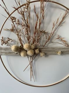 dried flowers are arranged on a metal circle