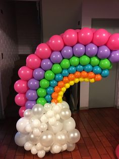 a bunch of balloons that are in the shape of a rainbow