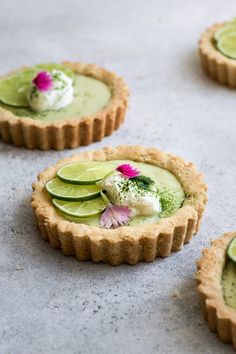 small tarts with limes and whipped cream on them