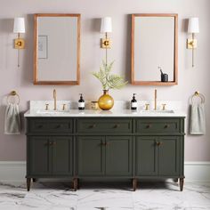 a bathroom vanity with two mirrors above it and a vase on the counter next to it