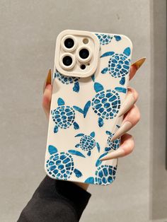 a woman holding an iphone case with blue turtles on it