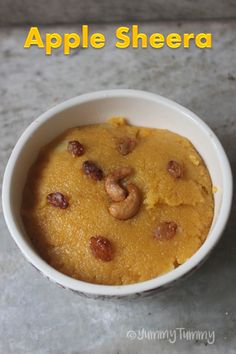 a bowl filled with food sitting on top of a table next to an apple slice