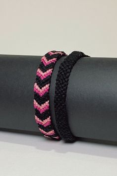 two black and pink bracelets sitting on top of a yoga mat