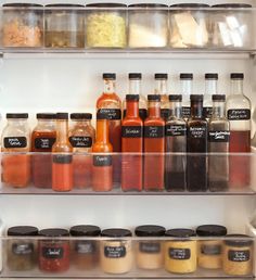 an open refrigerator filled with lots of different types of spices and condiments on shelves