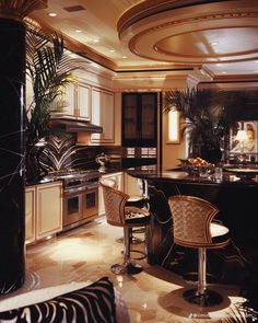 an elegant kitchen with marble counter tops and zebra print bar stools