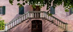 a pink house with green shutters and stairs