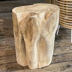 a wooden stool sitting on top of a hard wood floor next to a wicker basket