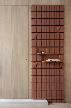 a book shelf with books on it in front of a wall made of wood planks