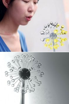 a woman is blowing bubbles in front of a wind spinner that looks like a dandelion