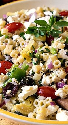 a bowl filled with pasta salad on top of a table