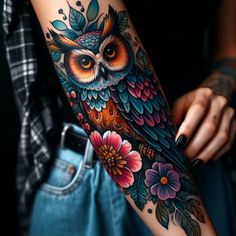 an owl tattoo on the arm with flowers