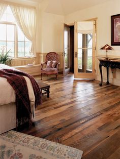 a bedroom with wood floors and white walls, has a fireplace in the corner next to it