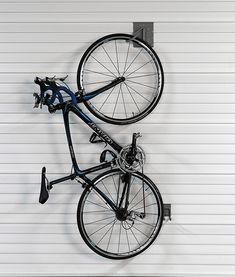 a bicycle mounted to the side of a garage wall with wheels on it's back