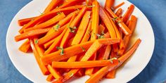 a white plate topped with sliced up carrots on top of a blue table cloth