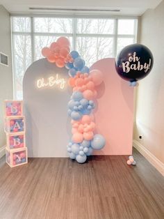 a balloon arch is decorated with pink, blue and white balloons for a baby shower