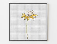 a cross - stitch picture of a yellow flower on a white background with black frame