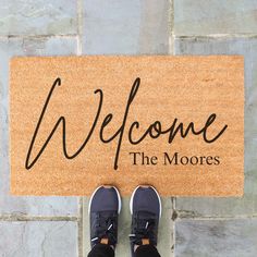 a welcome mat with someone standing in front of it that says, welcome the moores