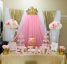 a table topped with lots of pink and gold desserts next to a canopy covered wall