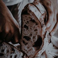 a person holding a piece of bread in their hands