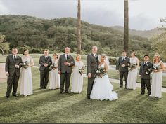 a bride and groom with their bridal party in front of palm trees on the golf course