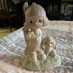 a ceramic figurine is sitting on a bed