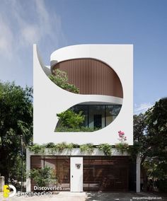 a white building with an interesting design on the front and side windows that have plants growing out of them